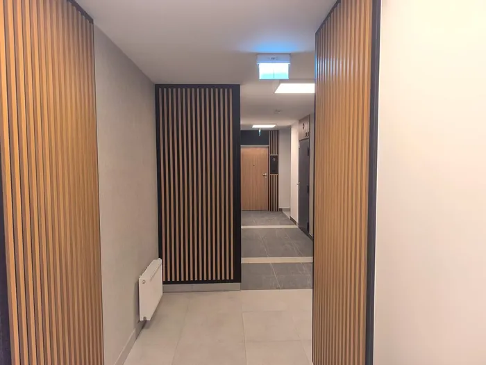 Korytarz z lamelami na czarnym tle, Apartamenty Pustułeczki na Ursynowie
