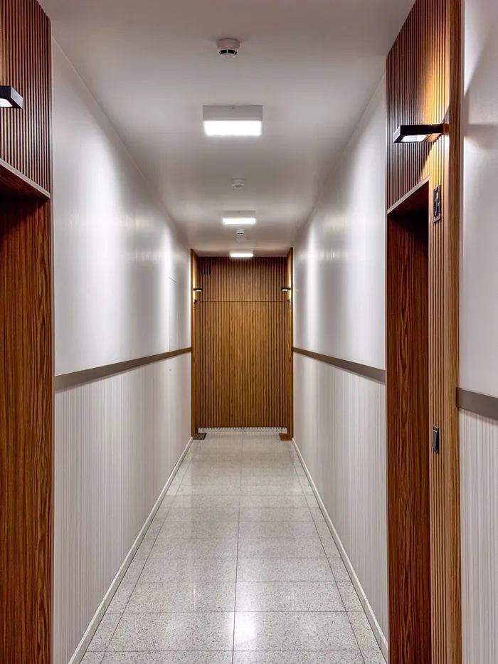 Korytarz z drewnianymi portalami drzwiowymi w Apartamentach RYTM