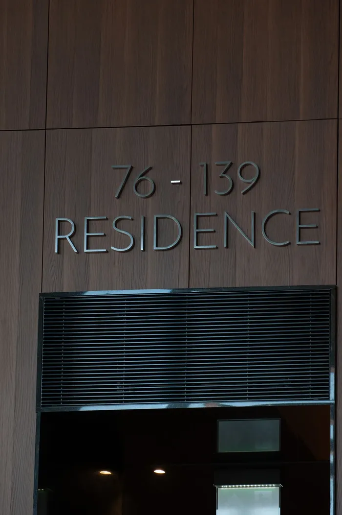 Napis 76–139 Residence na drewnianej okładzinie ściany
