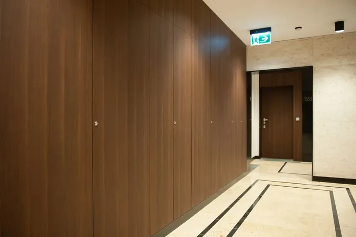 Korytarz z okładziną od posadzki do sufitu i ukrytymi drzwiami rewizyjnymi, Mennica Residence