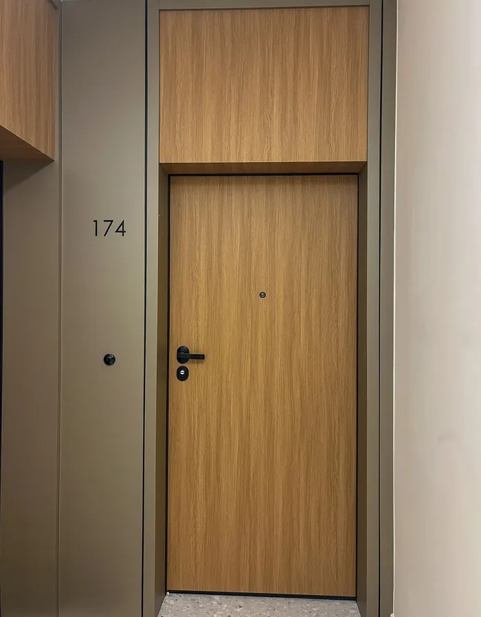 Drzwi do mieszkania 174 z panelem nad drzwiami w kolorze dębu, Modern Mokotów w Warszawie