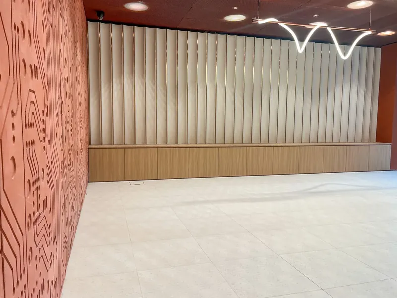 Hol w budynku Modern Mokotów: niska szafka w kolorze dębu pod ścianą z pionowymi panelami