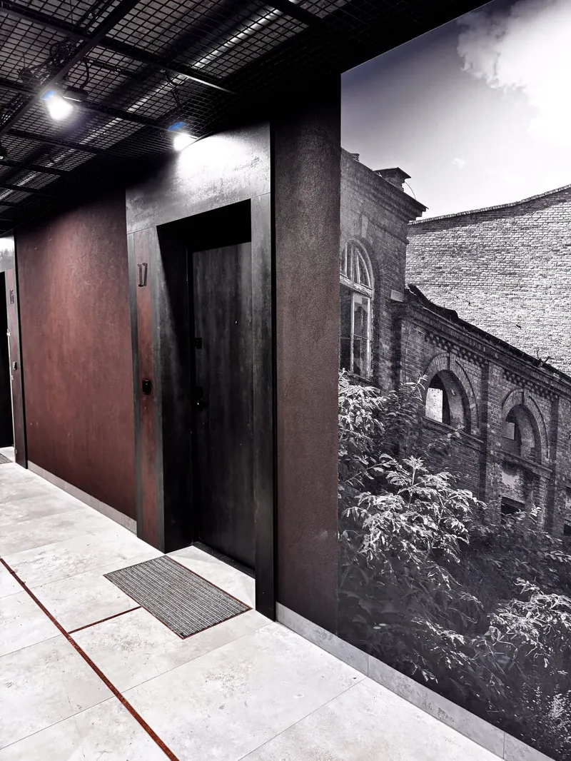 Korytarz w Warzelni Bohema: grafitowe portale drzwiowe i ściana z fotografią dawnej warzelni